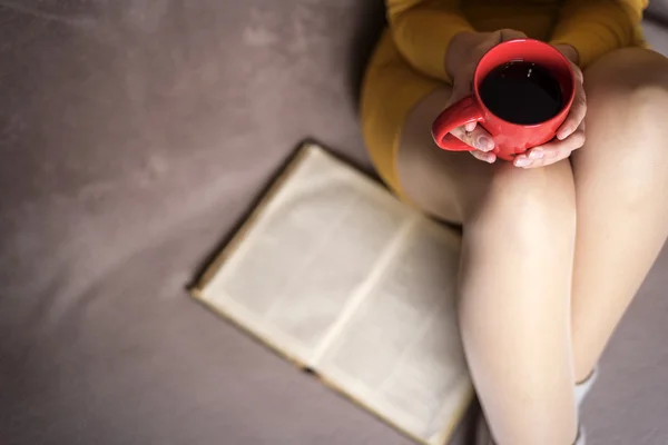 Vrouw met oud boek en kopje koffie. — Stockfoto