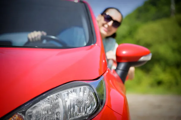 Mutlu kadın kırmızı araba. — Stok fotoğraf