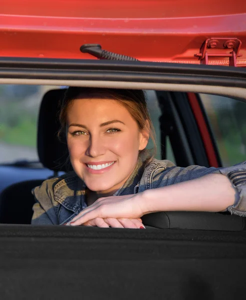 Leende kvinna sitter i bilen. — Stockfoto