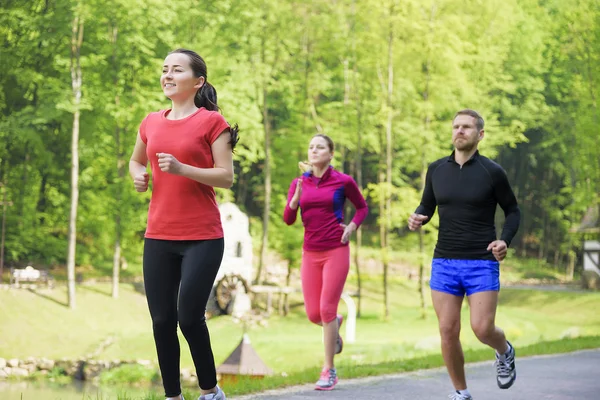 Smiling friends running outdoors. — Stock Photo, Image