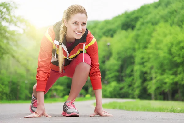 Atractiva mujer rubia corriendo en pista al aire libre . —  Fotos de Stock