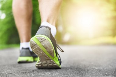 Koşucu ayakları yolda koşuyor.