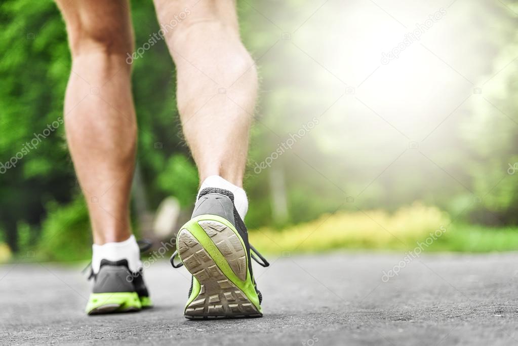 Athlete runner feet running on road.