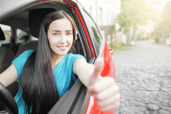 Gelukkig lachend meisje in een rode auto. — Stockfoto