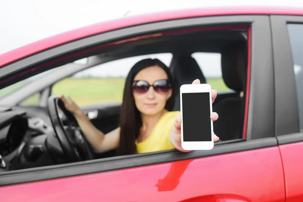 Řidič žena ukazující její smartphone. — Stock fotografie