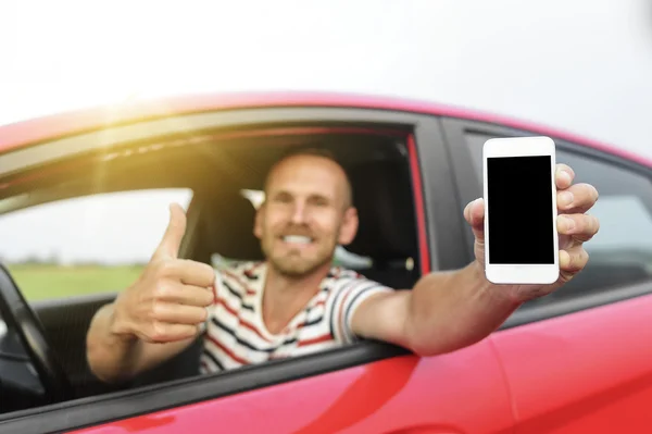 Mann im Auto zeigt Smartphone. — Stockfoto