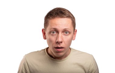A surprised young man with a shocked facial expression looking directly at the camera against a white background.
