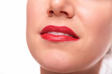 Kırmızı rujlu gülümseyen bir kadın temiz beyaz dişler gösteriyor, güzelliği, kendine güveni ve kadınsı zarafeti temsil ediyor..