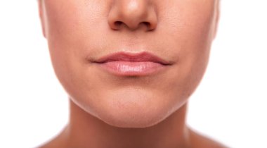 Bir kadının yakın plan görüntüsü, alt yüz doğal dudak, çene ve deri dokusunu temiz ve minimum güzellik konseptiyle gösterir..