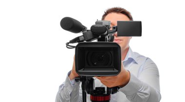 Beyaz arka planda tripodun üzerinde büyük bir video kamerayla çekim yapan profesyonel bir kameraman..