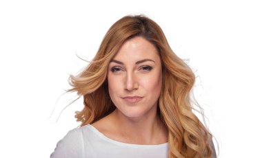 Yumuşak kıvrımlı, kendine güvenen sarışın bir kadın, beyaz bir arka plana karşı poz verir. Stüdyo resminde doğal güzellik ve zarif bir tarz sergiler..