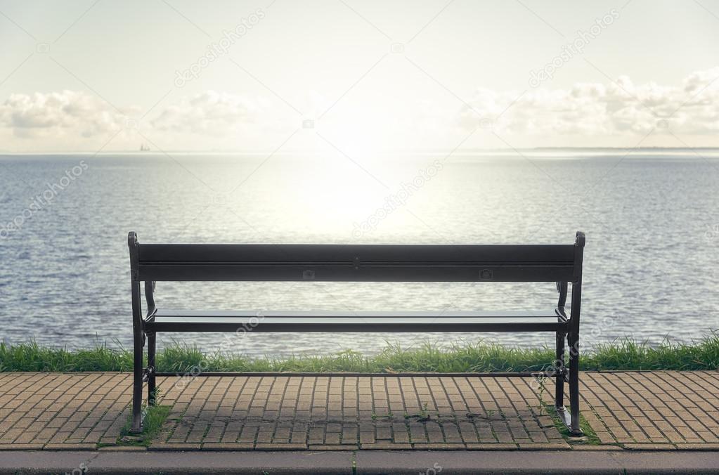 Wooden bench in front of the sea.