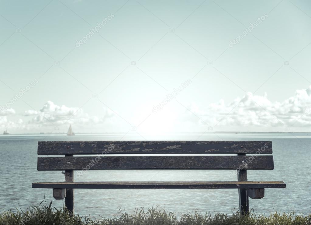 Wooden bench in front of the sea.