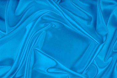 Zarif mavi saten kumaş yumuşak dairesel kıvrımlı parlak renklerle örtülmüş..