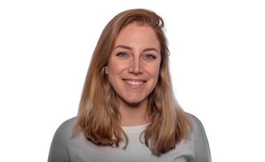 Stüdyoda gülümseyen bir kadının portresi, sarı saçlı ve mavi gözlü beyaz arka planda..