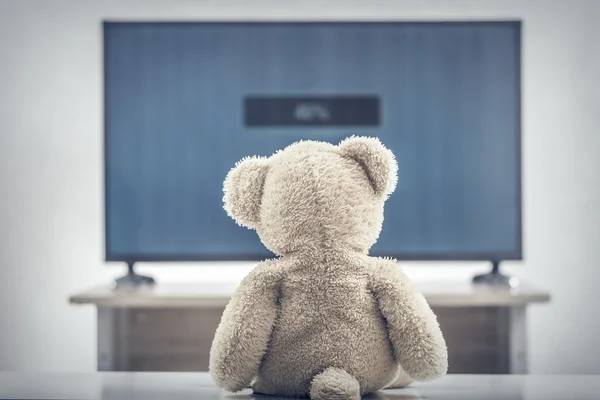 Teddy bear watching television. — Stock Photo, Image