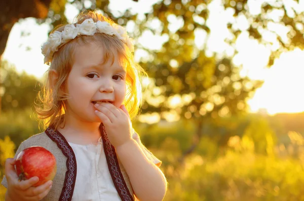 Flicka med äpple på sunset — Stockfoto