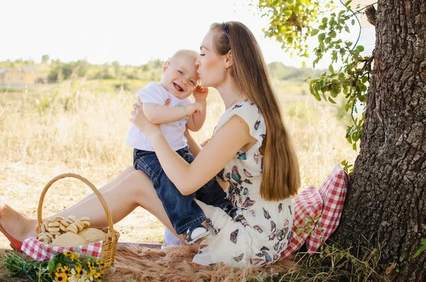 Mamma kysser son under träd — Stockfoto