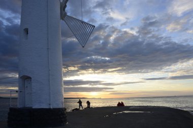 Günbatımı üzerinde deniz feneri ile