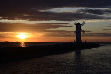 Günbatımı üzerinde deniz feneri ile