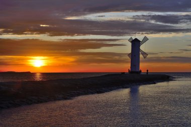 Günbatımı üzerinde deniz feneri ile