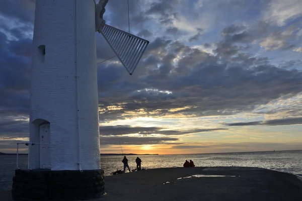 Sonnenuntergang über dem Meer mit Leuchtturm — Stockfoto