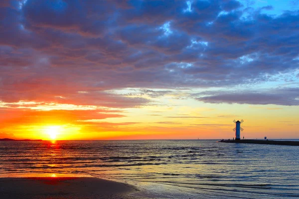 Sonnenuntergang über dem Meer mit Leuchtturm — Stockfoto