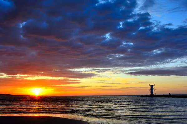 Sonnenuntergang über dem Meer mit Leuchtturm — Stockfoto