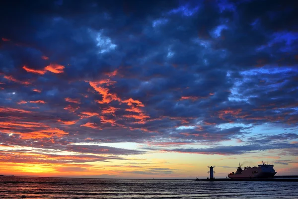 Sunset over the sea with lighthouse — Stock Photo, Image