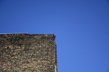 Mavi gökyüzü arka plan üzerinde eski tuğla duvar