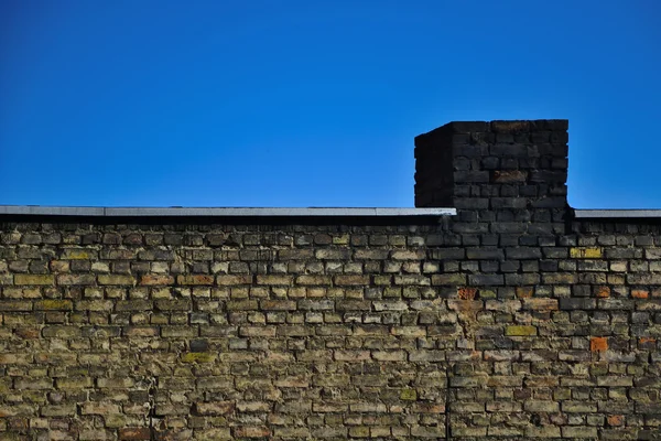 Antigua pared de ladrillo sobre un fondo de cielo azul — Foto de Stock