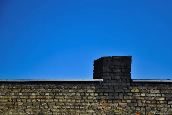 Antigua pared de ladrillo sobre un fondo de cielo azul — Foto de Stock