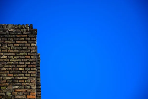 Mavi gökyüzü arka plan üzerinde eski tuğla duvar — Stok fotoğraf