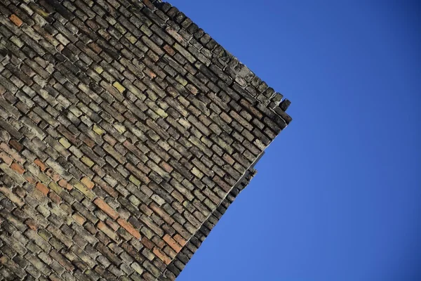 Stary mur z cegły na tle niebieskiego nieba — Zdjęcie stockowe