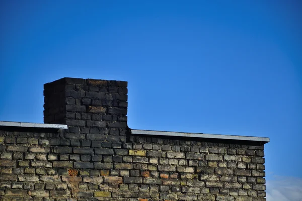 Gammal tegelvägg på en bakgrund av blå himmel — Stockfoto