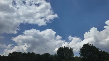 Parlak mavi gökyüzü altında hareket eden bulutların hızlandırılması, sinematik doğal hava görüntüleri