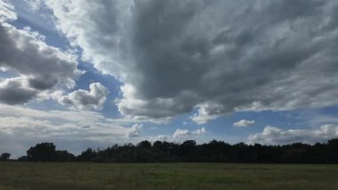 Zaman atlaması dramatik kümülüs ve fırtına bulutlarını yakalıyor bir orman ve açık çayır üzerinde şekilleniyor. Hava çalışmaları, sinematik doğa görüntüleri ve atmosferik arka plan görüntüleri için mükemmel.