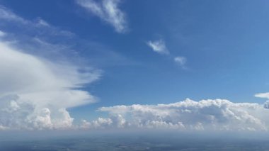 Derin mavi gökyüzüne doğru yükselen kümülüs bulutlarının yavaş çekim görüntüleri, insansız hava aracı tarafından yakalanır.