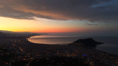 Türkiye 'nin Alanya kentinin hava panoramik manzarası, gün doğumunda hafif aydınlatılmış şehir manzarası, kıvrımlı kıyı şeridi ve sakin Akdeniz koyunu gösteriyor