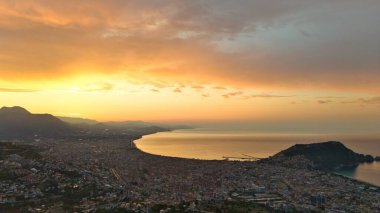 Türkiye 'nin Alanya kıyı manzarası, yüksek bir perspektiften geniş kıyı şeridi ve kentsel manzarayla altın saat içinde ele geçirildi