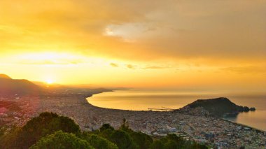 Türkiye 'nin Alanya kıyı manzarası, yüksek bir perspektiften geniş kıyı şeridi ve kentsel manzarayla altın saat içinde ele geçirildi