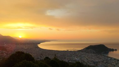 Türkiye 'nin Alanya kıyı manzarası, yüksek bir perspektiften geniş kıyı şeridi ve kentsel manzarayla altın saat içinde ele geçirildi