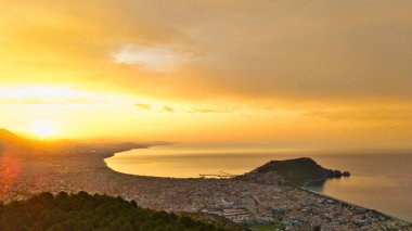 Türkiye 'nin Alanya kıyı manzarası, yüksek bir perspektiften geniş kıyı şeridi ve kentsel manzarayla altın saat içinde ele geçirildi