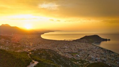 Türkiye 'nin Alanya kıyı manzarası, yüksek bir perspektiften geniş kıyı şeridi ve kentsel manzarayla altın saat içinde ele geçirildi