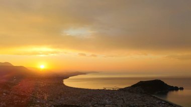 Türkiye 'nin Alanya kıyı manzarası, yüksek bir perspektiften geniş kıyı şeridi ve kentsel manzarayla altın saat içinde ele geçirildi
