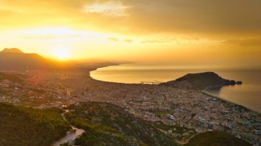 Türkiye 'nin Alanya kıyı manzarası, yüksek bir perspektiften geniş kıyı şeridi ve kentsel manzarayla altın saat içinde ele geçirildi