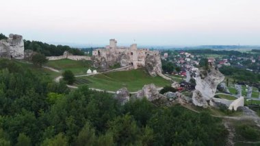 Polonya 'nın Ogrodzieniec kentindeki ortaçağ taş kalesinin insansız hava aracı filmi dramatik kireçtaşı kayaları üzerinde yer alıyor ve kırsal alanla çevrili.
