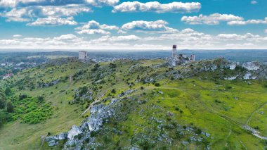 Polonya 'nın Çek Cumhuriyeti yakınlarındaki Olsztyn Kalesi' nin insansız hava aracı görüntüsü sıcak altın saat ışığıyla aydınlatılıyor. Jura Krakowsko-Çekoslovakya manzarasında küçük bir kasabanın üzerinde yükselen ortaçağ kireçtaşı kalesi.