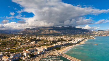 Kilise, sahil ve dağlarla dolu bir sahil şeridi dramatik bulutlar altında, Costa Blanca, Alicante, İspanya