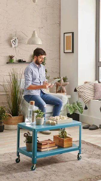 Man in the room, corner interior style, listening to the music with laptop and working from home. Modern decoration style.